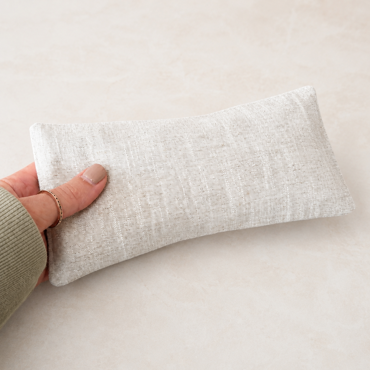 Lavender Eye Pillow with hand to show scale. Still by Ukiyo